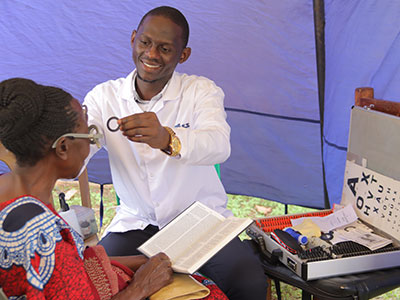 A woman gets her eyes checked during a medical outreach event in Uganda
