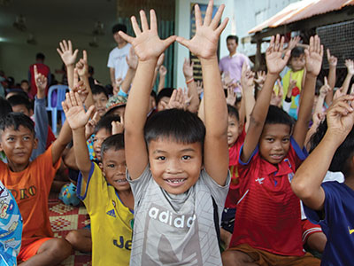 Smiling children raising their hands