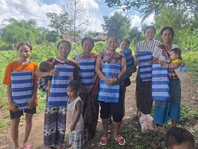 Refugees in Thailand receiving blue tarps to help protect them from the elements