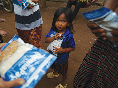 A young refugee receives MannaPack meals
