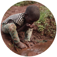 A child drinking dirty water in Uganda