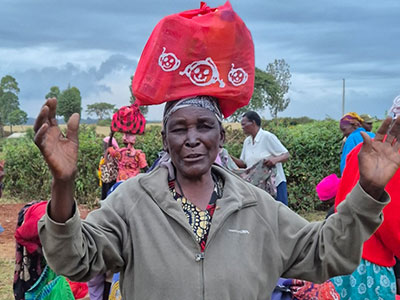 A widow happy to receive food and more during a Christmas outreach event in Kenya