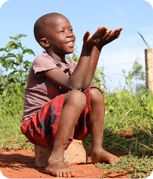A smiling child lifting up his hands like he's holding something A smiling child lifting up his hands like he's holding something