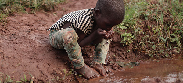 A child drinking dirty water in Uganda