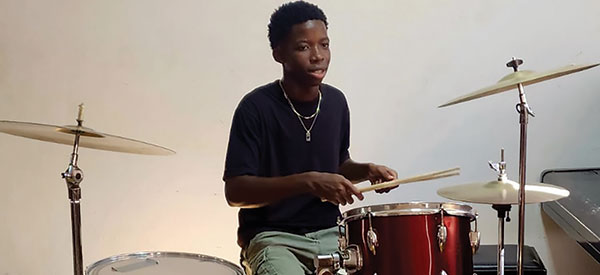 A young adult playing the drums during a worship service