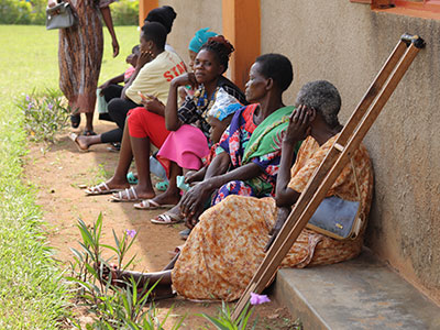 A woman sits with her crutch next to her waiting to be seen during a medical outreach event.