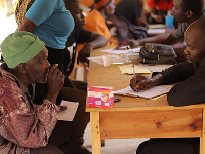 An older patient converses with a medical professional during a medical outreach event
