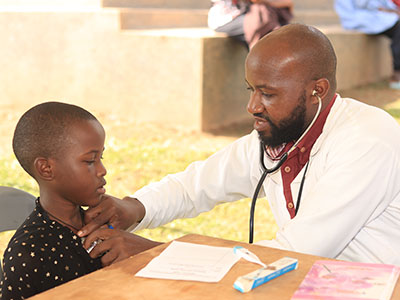 A medical professional listens to a child's heartbeat